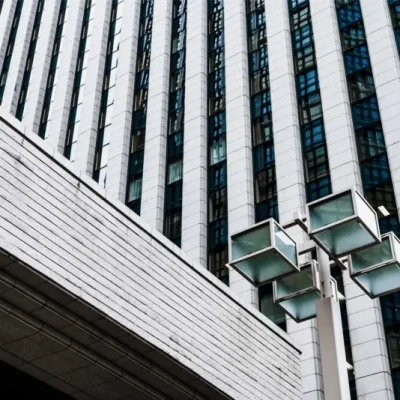 Fachada de un edificio de oficinas de varias plantas con una farola de diseño en primer plano